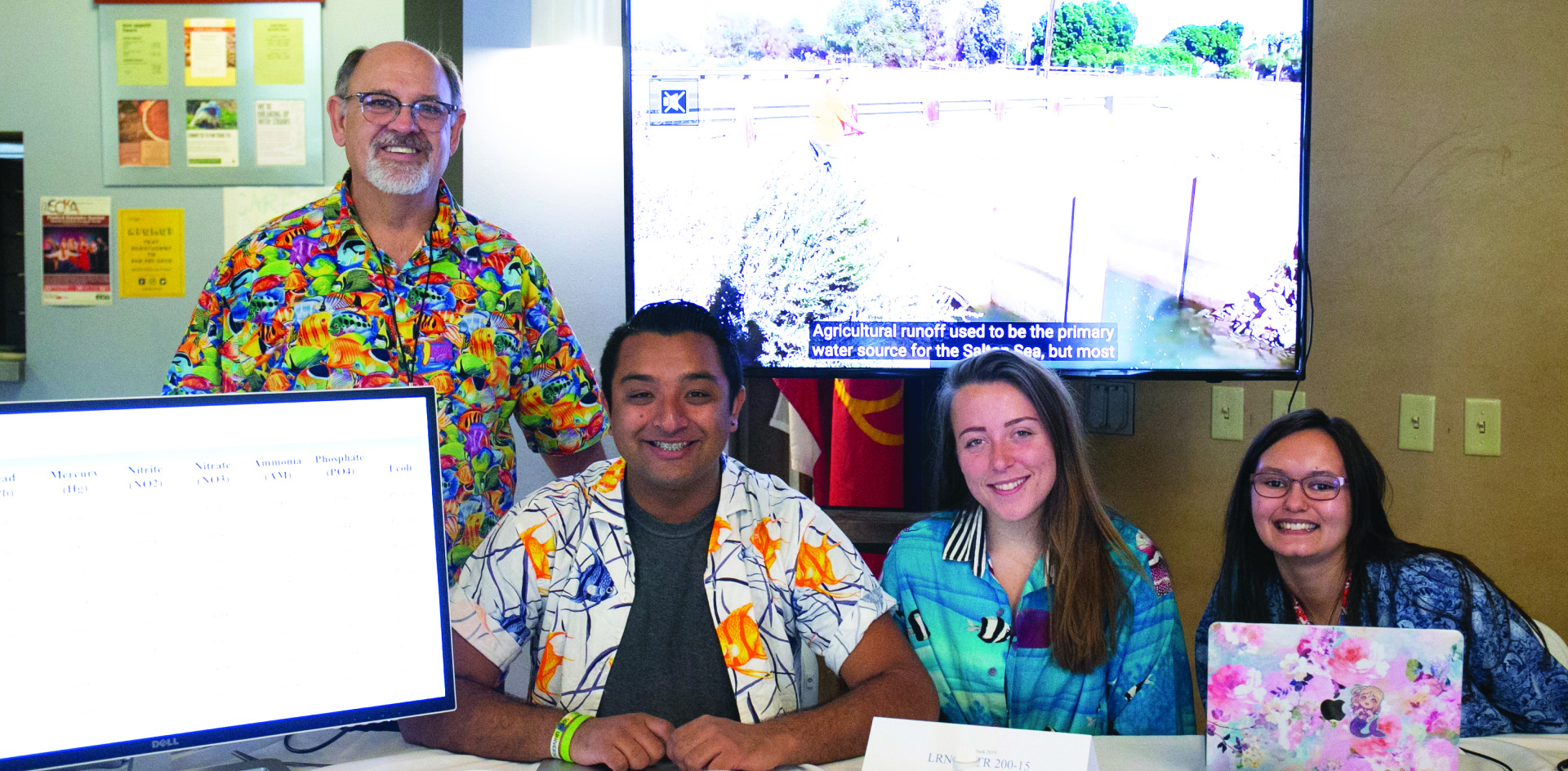 Image of a Learning Cluster booth with students and a professor.