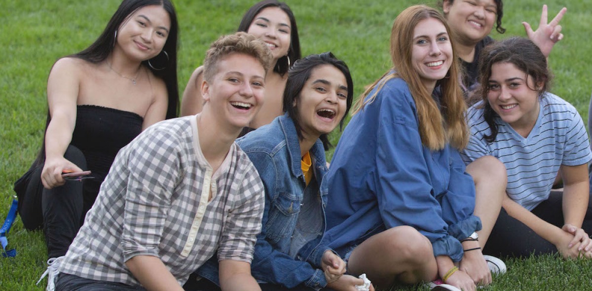 Soka University students sitting on grass