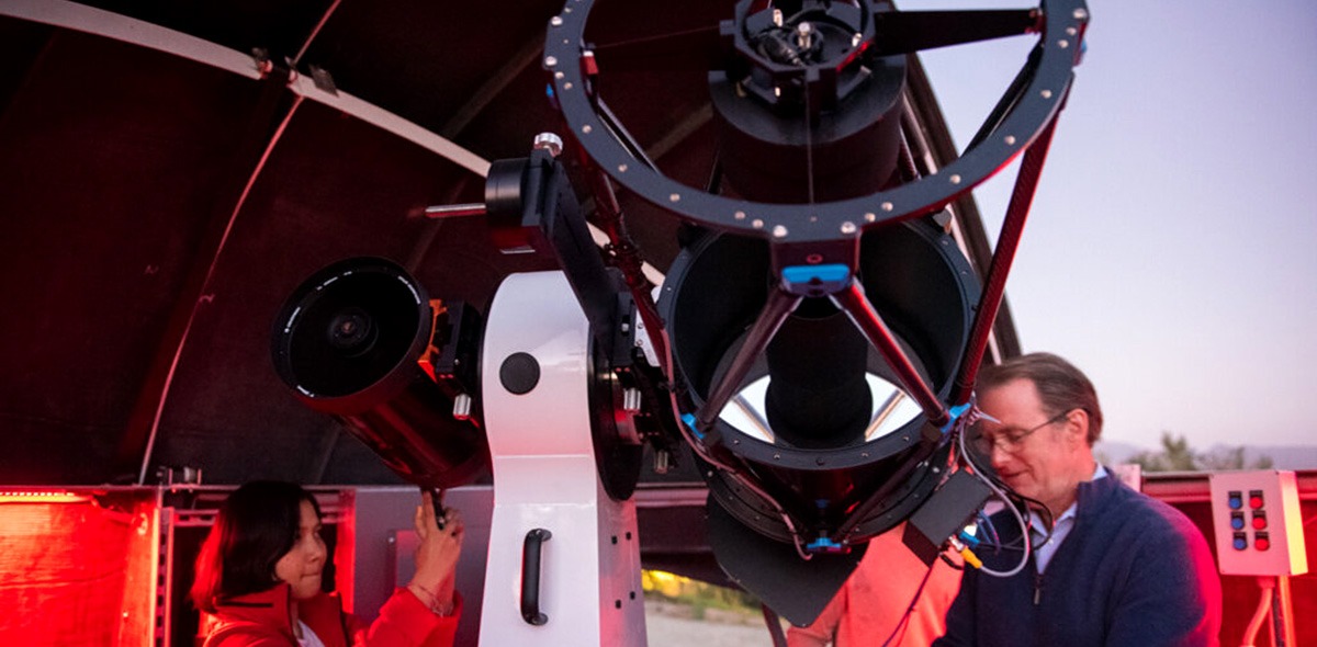 Professor and student operate telescope and other observatory equipment