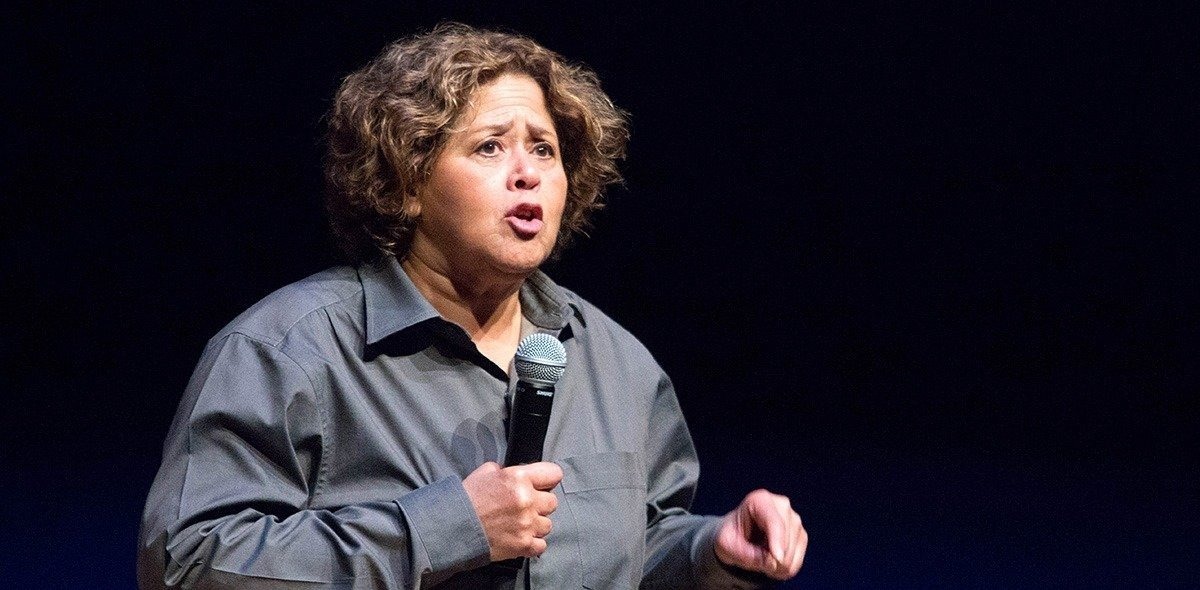 Anna Deavere Smith holding a microphone and speaking