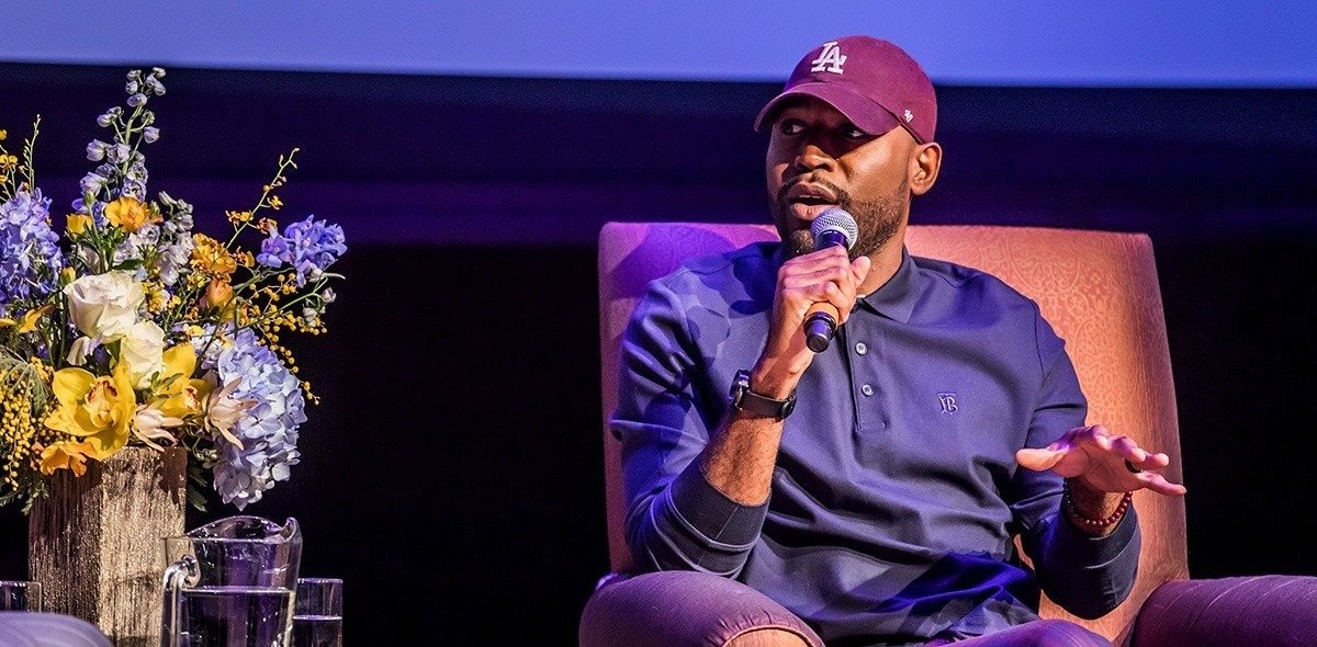 Karamo Brown sitting in a chair and speaking into a microphone