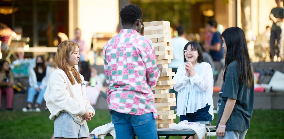 Students play giant jenga outside.