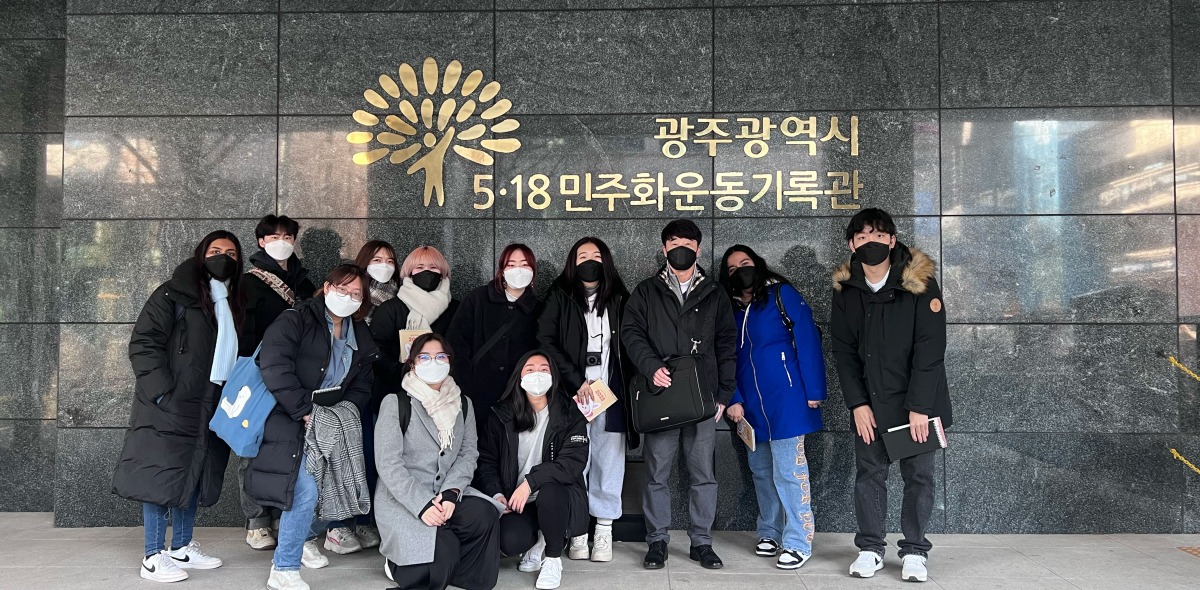 Students pose outside a building during their Learning Cluster