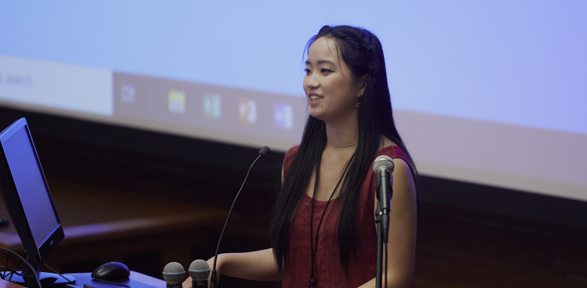 A SIGS Summer Program participant stands at a podium and gives a speech