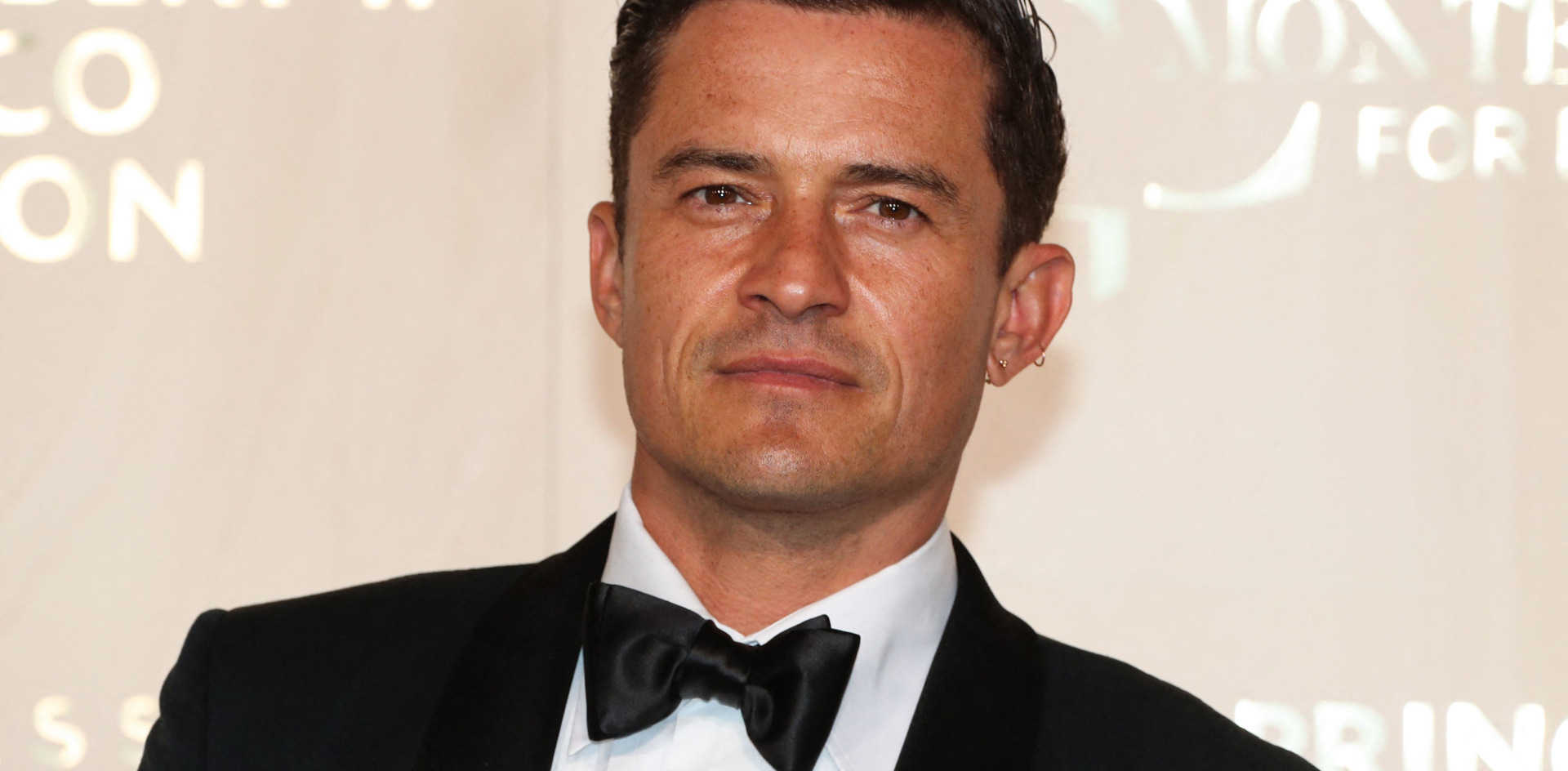 Orlando Bloom poses in a tuxedo at an event. Photo by Valery Hache/AFP via Getty Images
