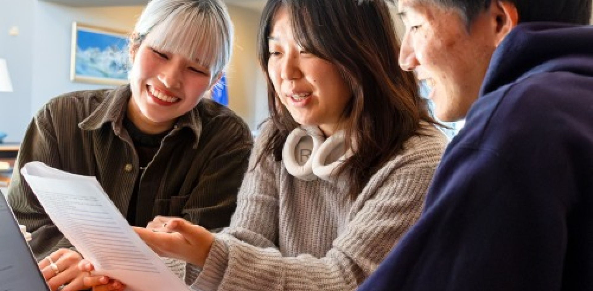 Three students reviewing work on a piece of paper