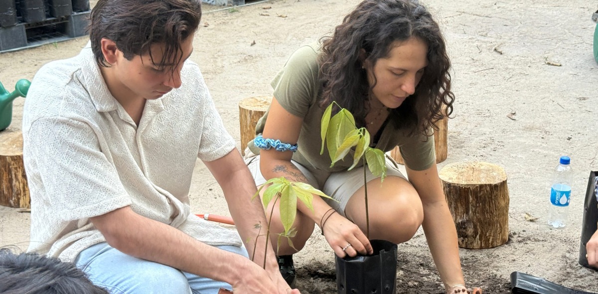 Two students dig with shovels during a native plant species workshop.