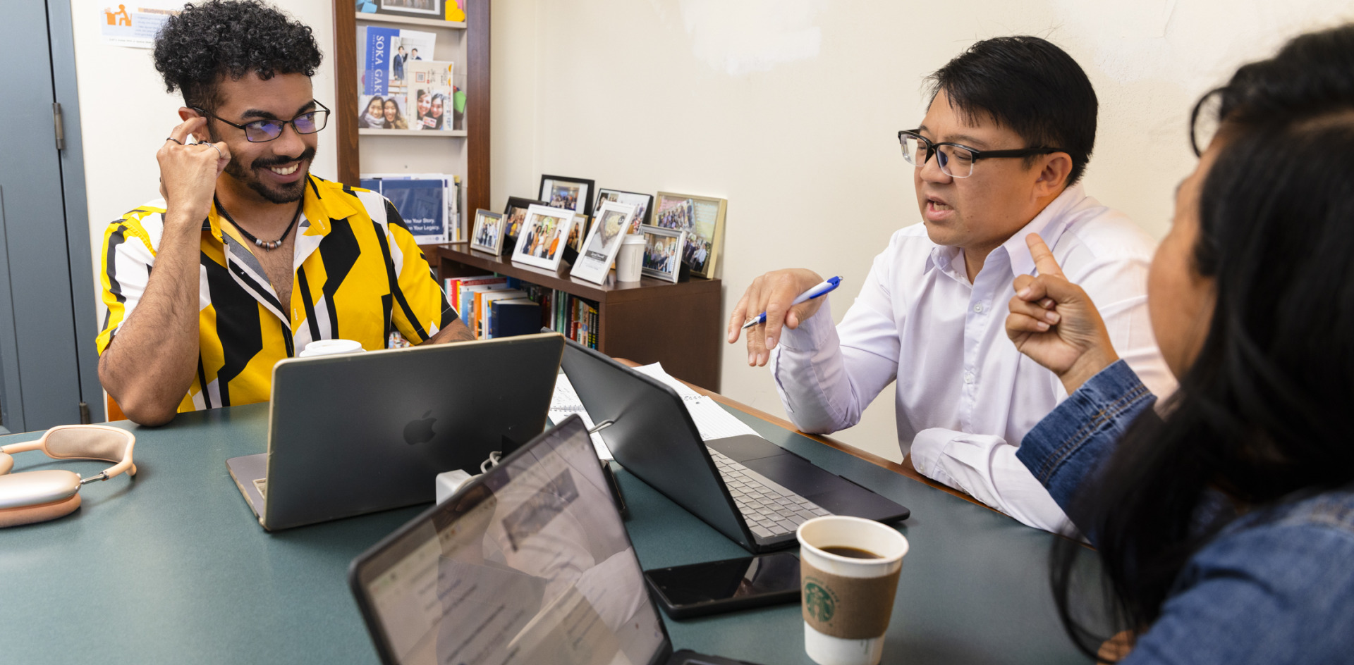 Three students work together on laptops
