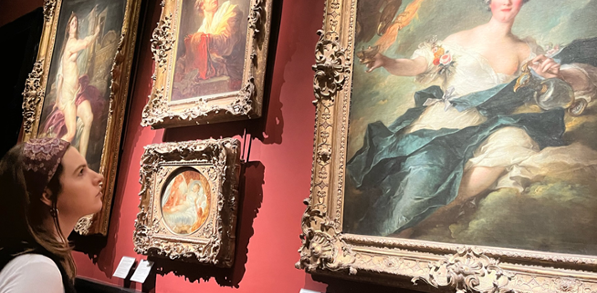 A girl looks at a painting in an art museum