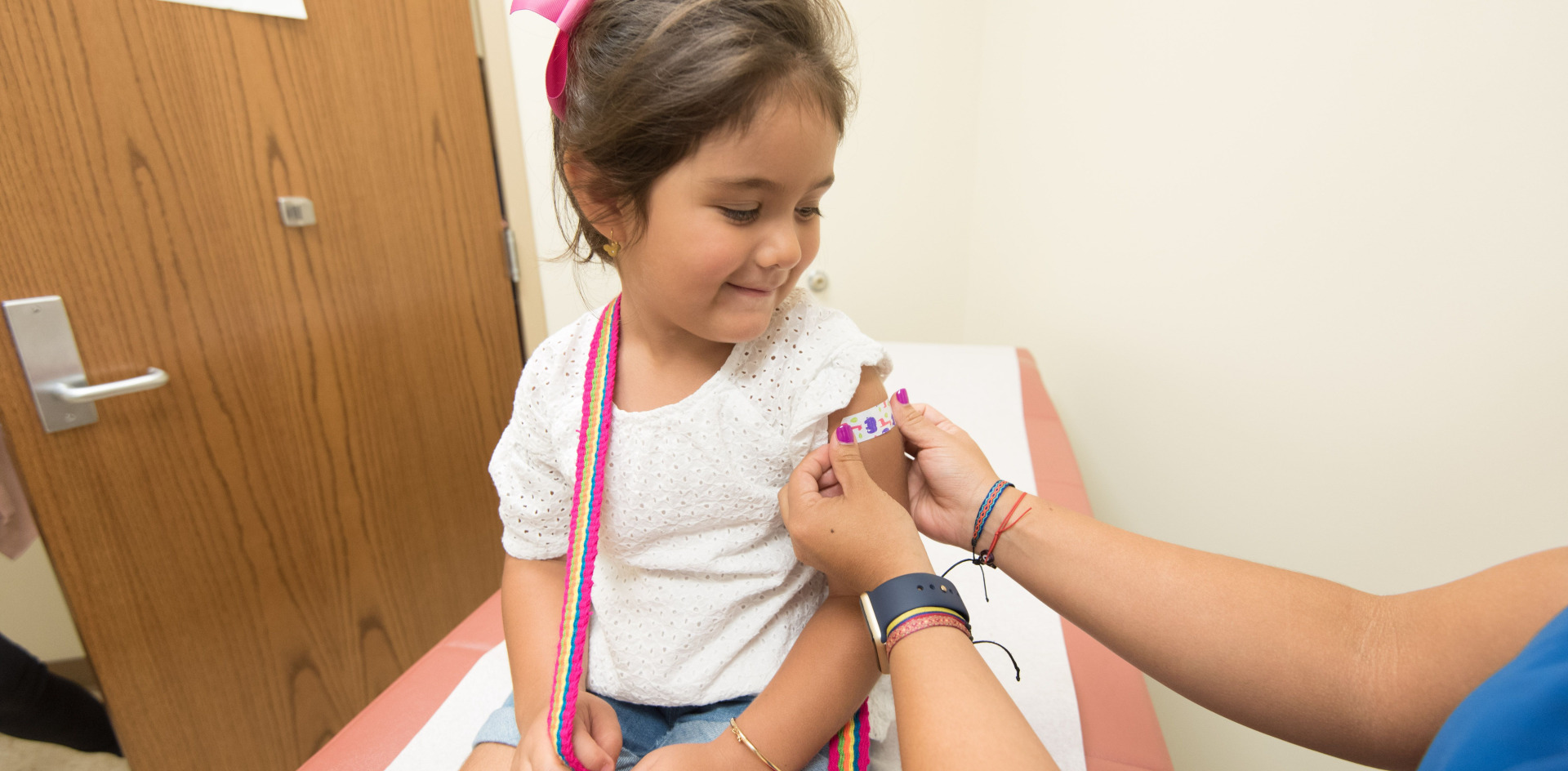 A girl receives a band-aid from a school nurse
