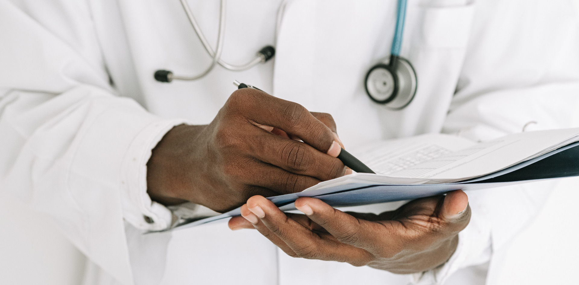 Doctor writing on a clipboard with a stethoscope