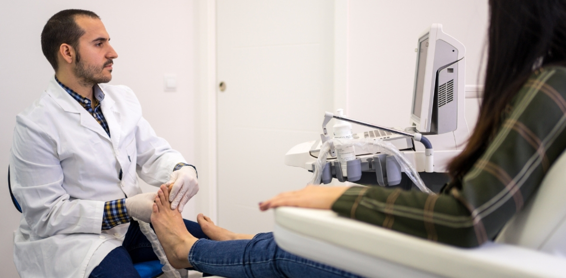 A podiatrist examining a woman's foot and ankles