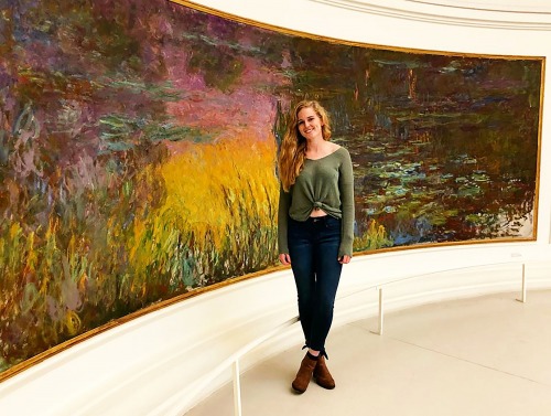 Student standing in front of large painting in France