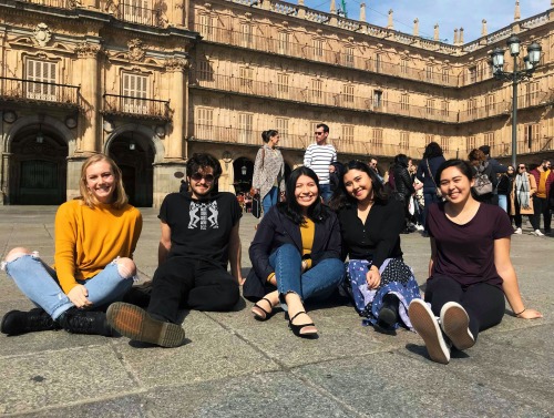Group of students seated in front of large building in Salamanca