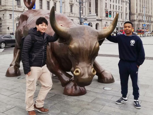 Students with statue of a bull in Shanghai
