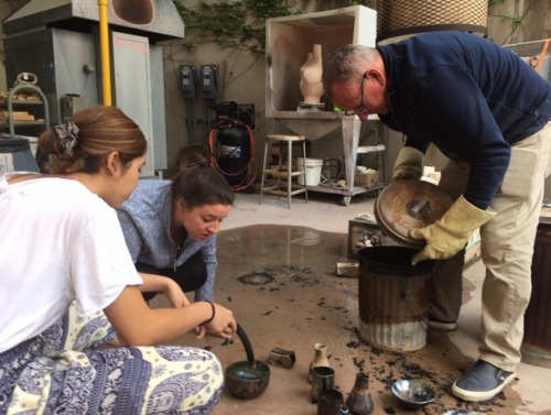 Image of students working with the ceramics instructor.