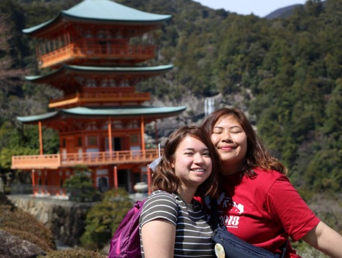 Two students in front of traditional Japanese architecture