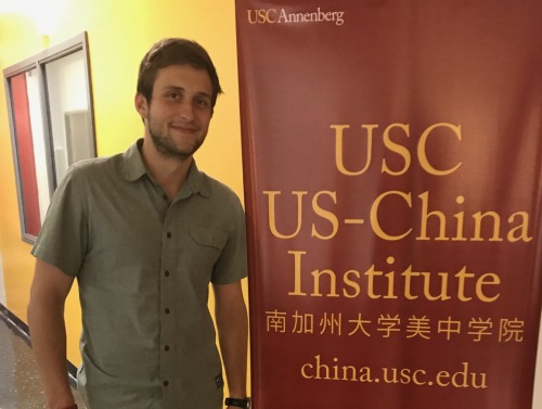 Student standing by a sign. 