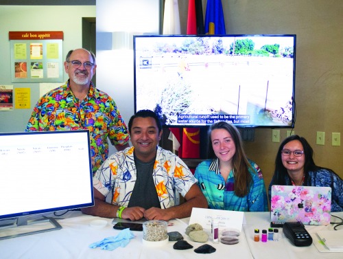 Image of a Learning Cluster booth with students and a professor.