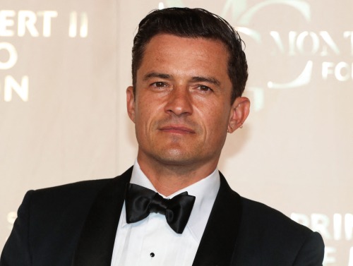 Orlando Bloom poses in a tuxedo at an event. Photo by Valery Hache/AFP via Getty Images