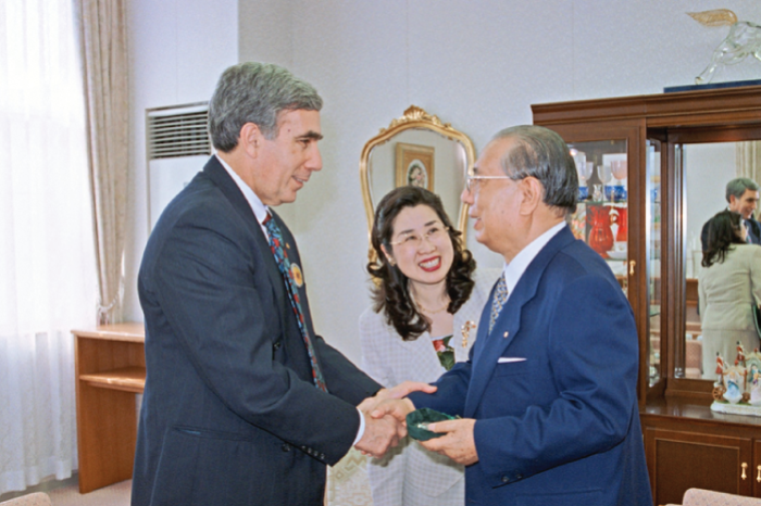 Daisaku Ikeda and David Krieger, two champions of the nuclear disarmament movement, shake hands and smile at one another