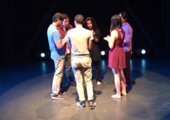 Actors stand in a circle on stage