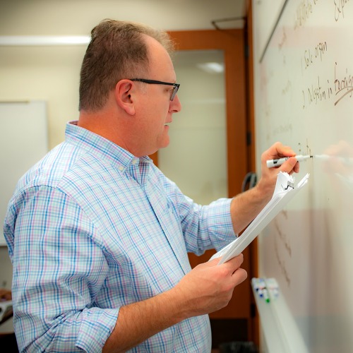 Peter Burns writes on a whiteboard