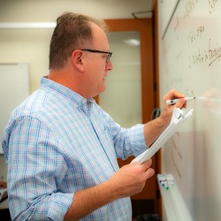 Peter Burns writes on a whiteboard