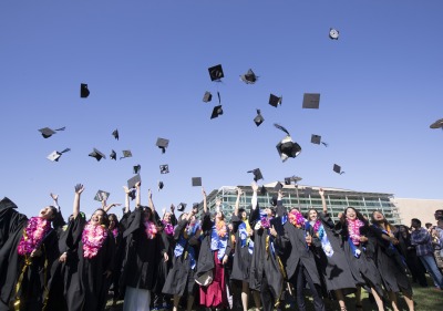 Image of students throwing graduation caps.