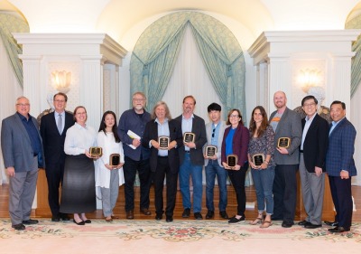 Faculty holding awards at a banquet.