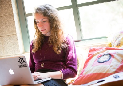 Image of student working on laptop in residence hall.