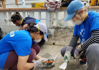 Students working in masks to help build houses