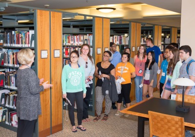 Image of a librarian speaking to students in the library.