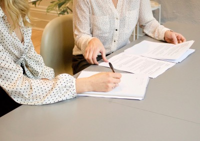 Image of two people at a table with papers.