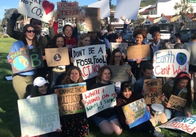 Students demonstrate with signs encouraging climate action 