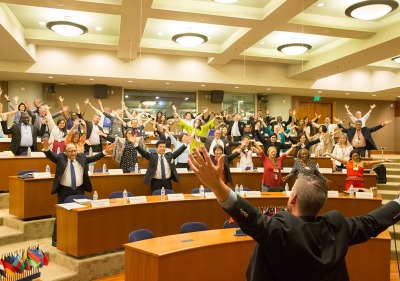 People in a classroom raising their arms in celebration 