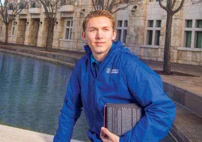 Student holding book in front of Peace Lake