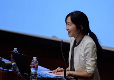 A female speaker presents during the symposium