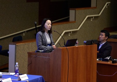 A female speaker presents during the symposium