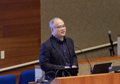 A male speaker presents during the symposium
