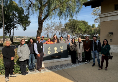 Writing Center staff gathered around a plaque titled "Wisdom, Courage, Compassion." 