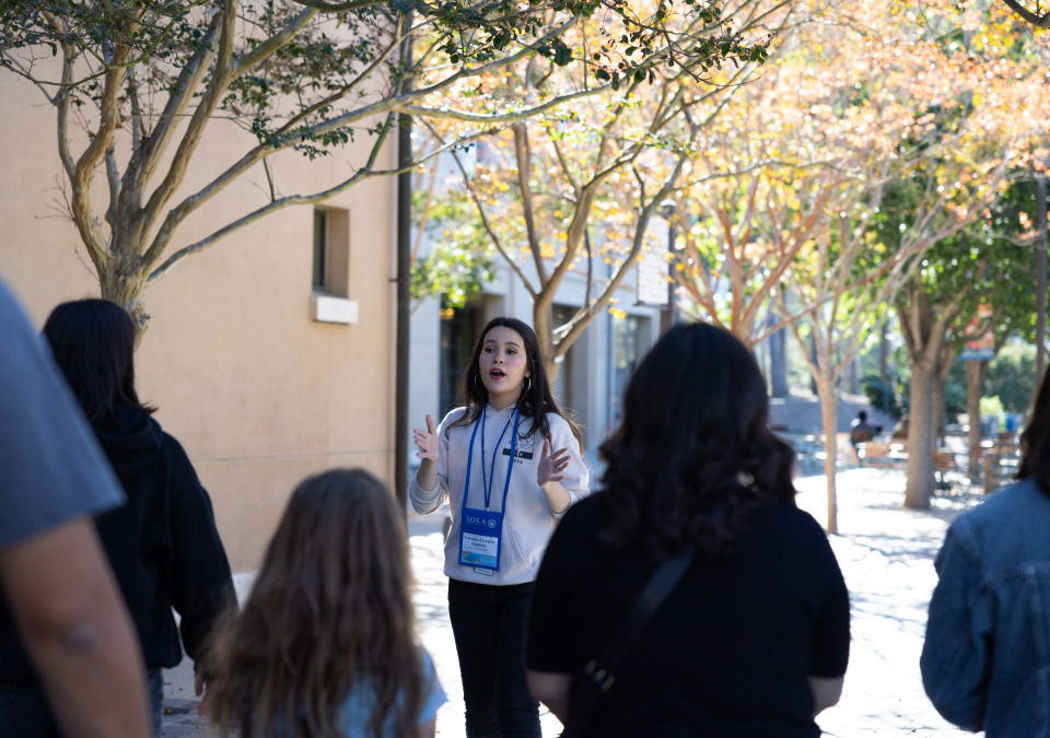 a student giving campus tour to a group of people