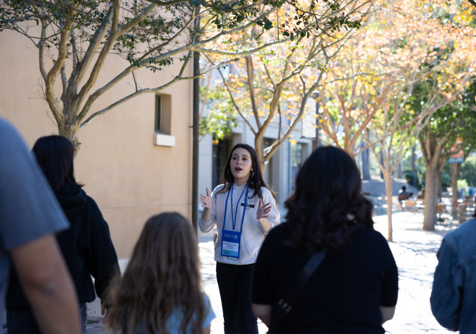a student giving campus tour to a group of people