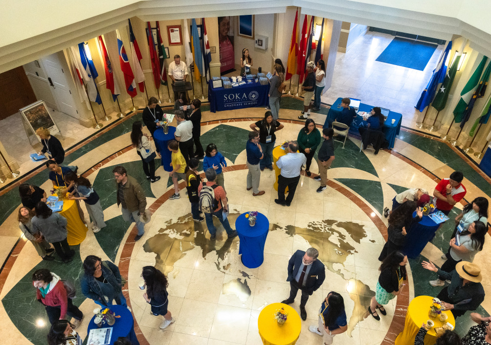 people standing and chatting on the floor featuring a world map