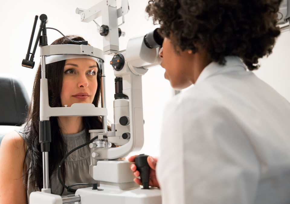An optometrist examining eyes for a woman