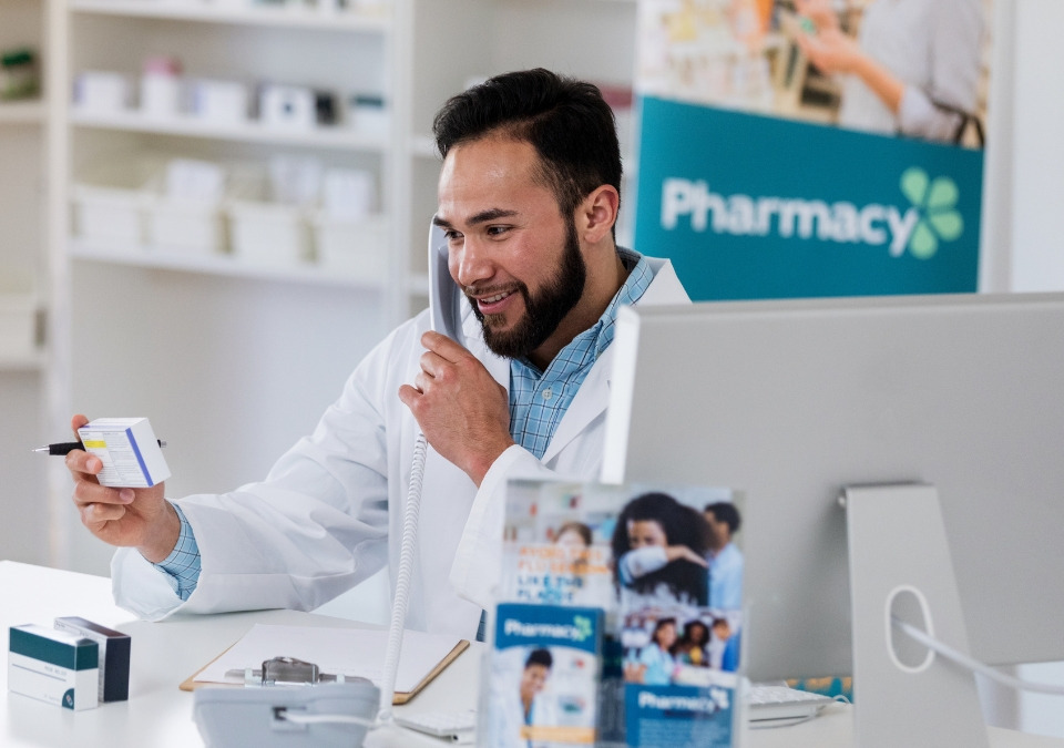 A pharmacist talking on a phone call and smiling