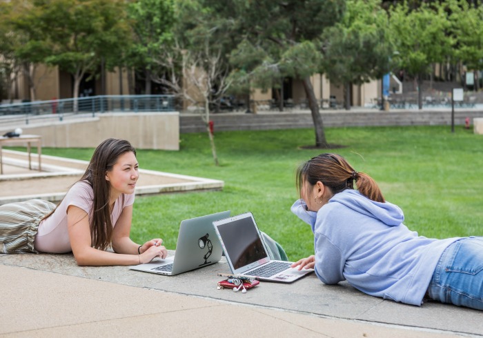 Image of students working outside on laptops.