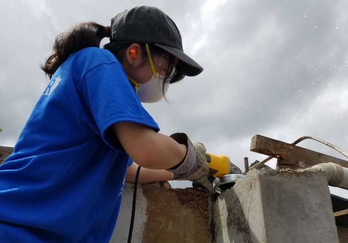 student working to rebuild house