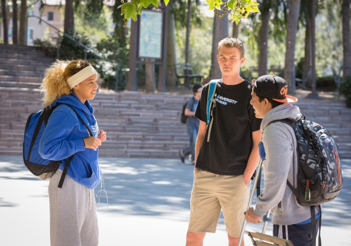 3 students standing and talking