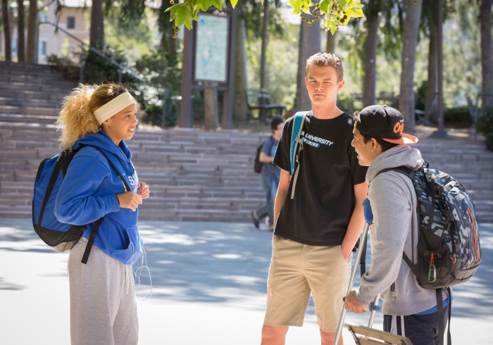 3 students standing and talking